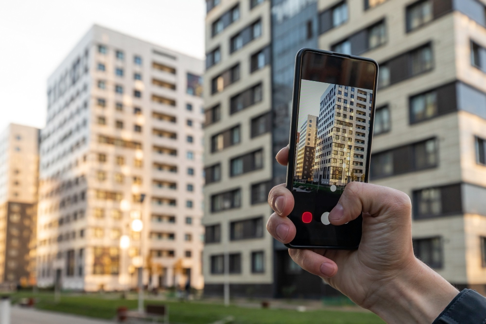 close-up-hands-real-estate-agent-with-phone-taking-pictures-new-residential-building